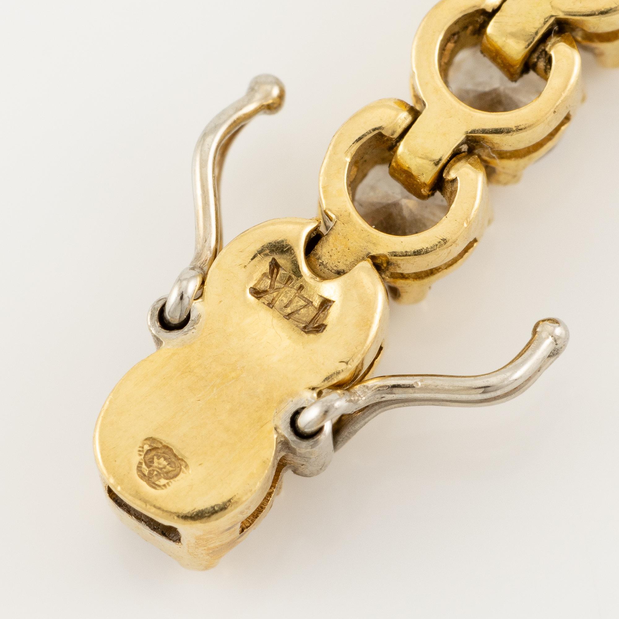 A tennis bracelet in 14K gold with round brilliant-cut diamonds.