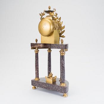 BORDSPENDYL, brännförgylld brons och älvdalsporfyr, Gustaviansk stil, omkring 1900. Pendel finns.