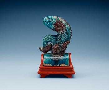 A turquoise and purple glazed roof top tile in the shape of a fish, Ming dynasty.