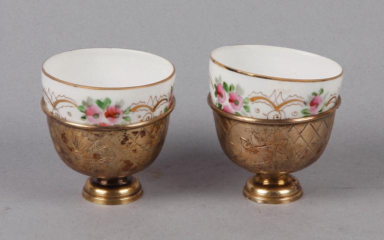 KOPPAR MED HÅLLARE, ett par, porslin resp silver, Ryssland resp Turkiet. Tidigt 1900-tal.