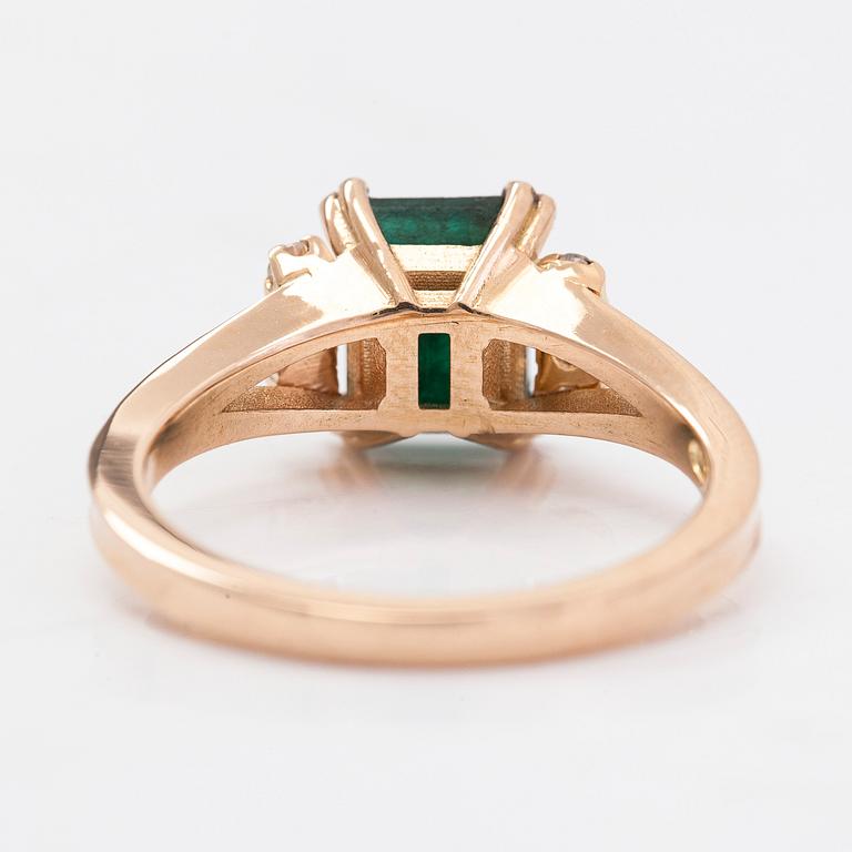 A 14K gold ring with an emerald and diamonds totalling ca. 0.12 ct.