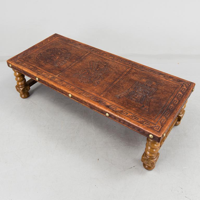 A Peruvian leather covered coffee table and pair of stools, second half of the 20th Century.