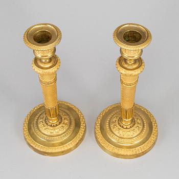 A pair of ormolu candlesticks, first half of the 19th century.