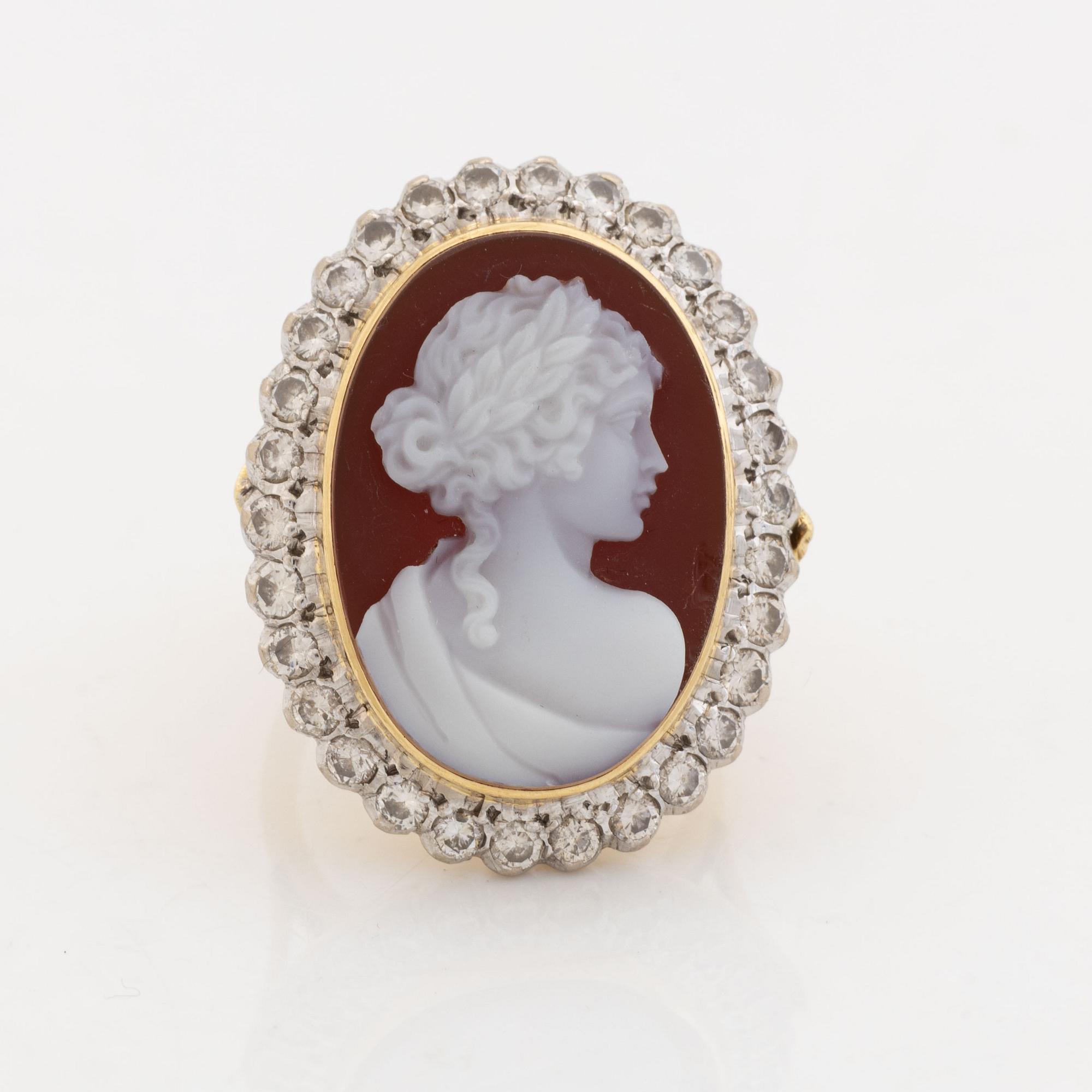 An 18K gold ring set with a hardstone cameo.