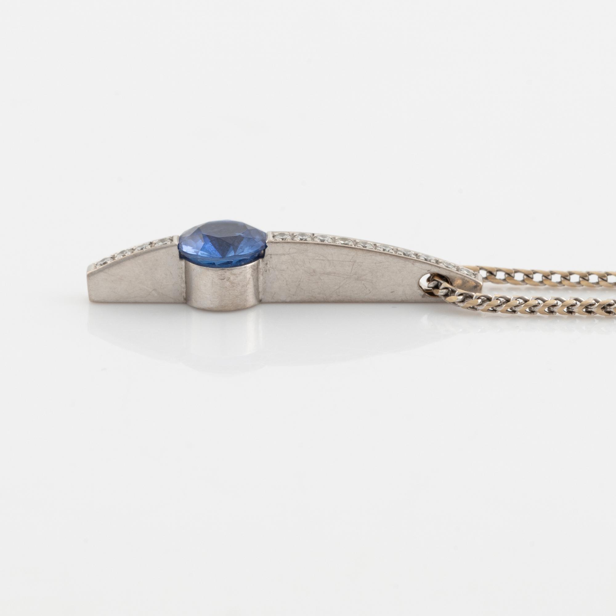 An 18K white gold necklace with a faceted sapphire and brilliant cut diamonds.