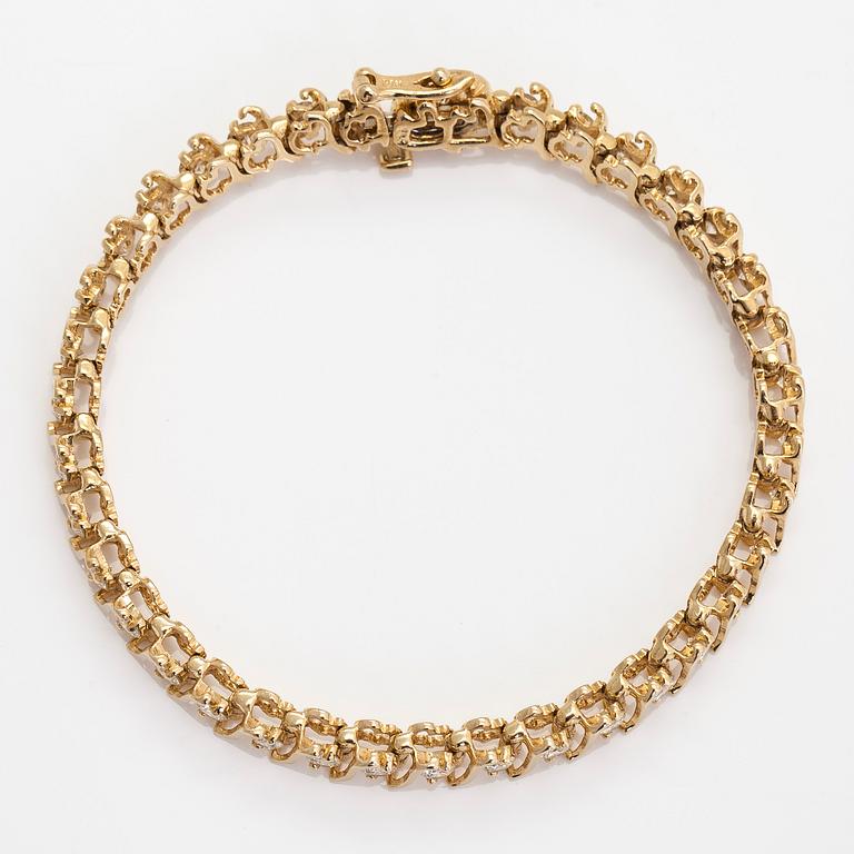 A 14K gold tennis bracelet, with brilliant-cut diamonds.