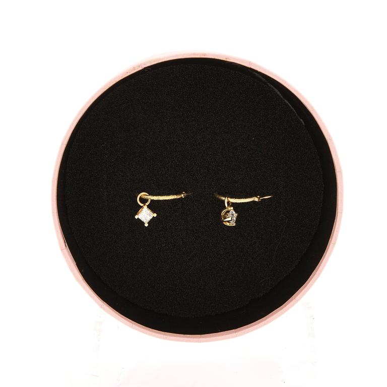 Earrings, a pair of hoops with pendants, one with a round brilliant-cut diamond, the other with a princess-cut diamond.