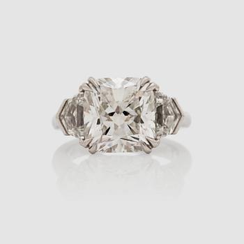 1152. Ring med en cushionslipad diamant, 5.50 ct, G/VVS2. Epauletteslipade sidostenar 1.16 ct totalt.