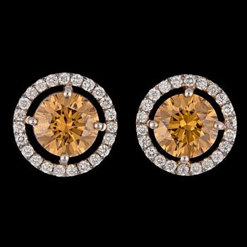 724. A pair of fancy deep brownish-yelow brilliant cut diamond earrings, 1.12 resp 1.17 cts.