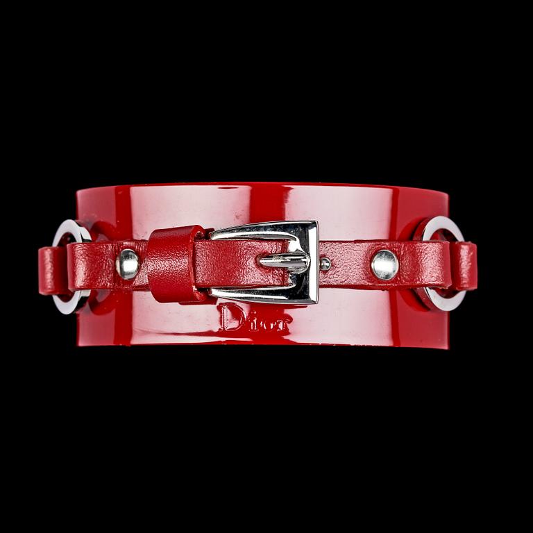 A red lacquer bracelet and a pair on earclips by Christian Dior.