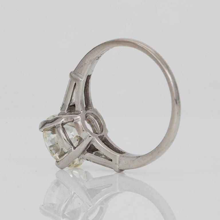 A circa 3.00 ct brilliant-cut diamond ring. Center stone flanked by two trapezoid-cut diamonds.