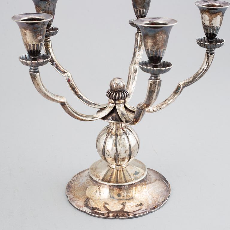 A pair of Swedish Grace silver candelbar for        five candles, mark of GAB, Stockholm, 1929.