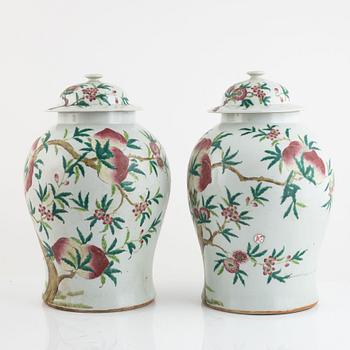 A pair of Chinese famille rose peach vases with covers, late Qing dynasty/circa 1900.