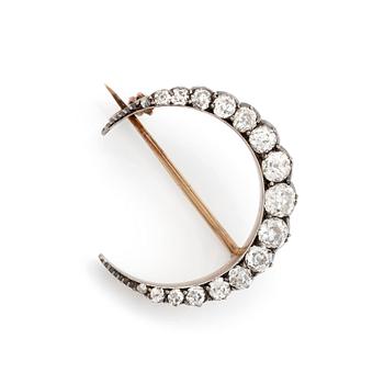 428. A Victorian crescent brooch in silver and gold set with old-cut dimonds.