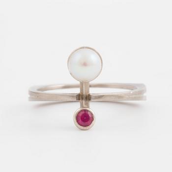 A ring set with a cultured pearl and a synthetic ruby.