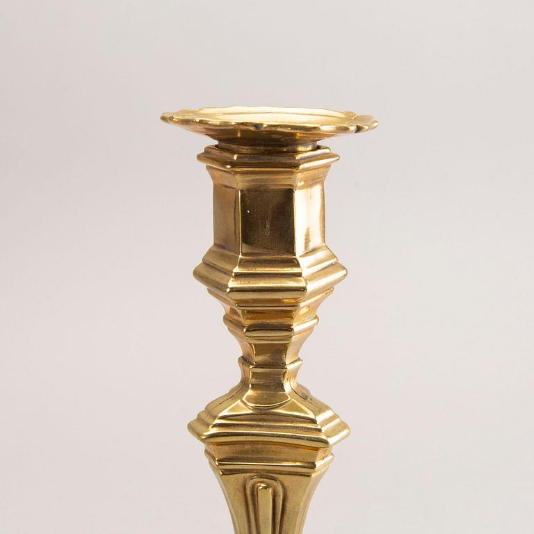 A pair of rococo brass candlesticks, possibly France.