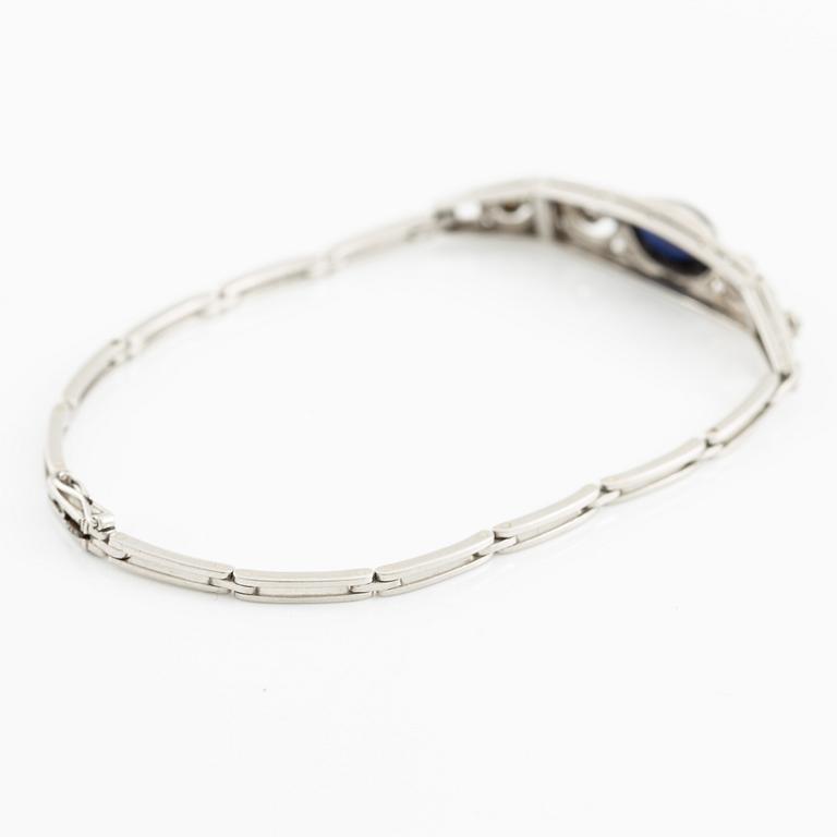 A bracelet in platinum set with old-cut diamonds and a blue stone.