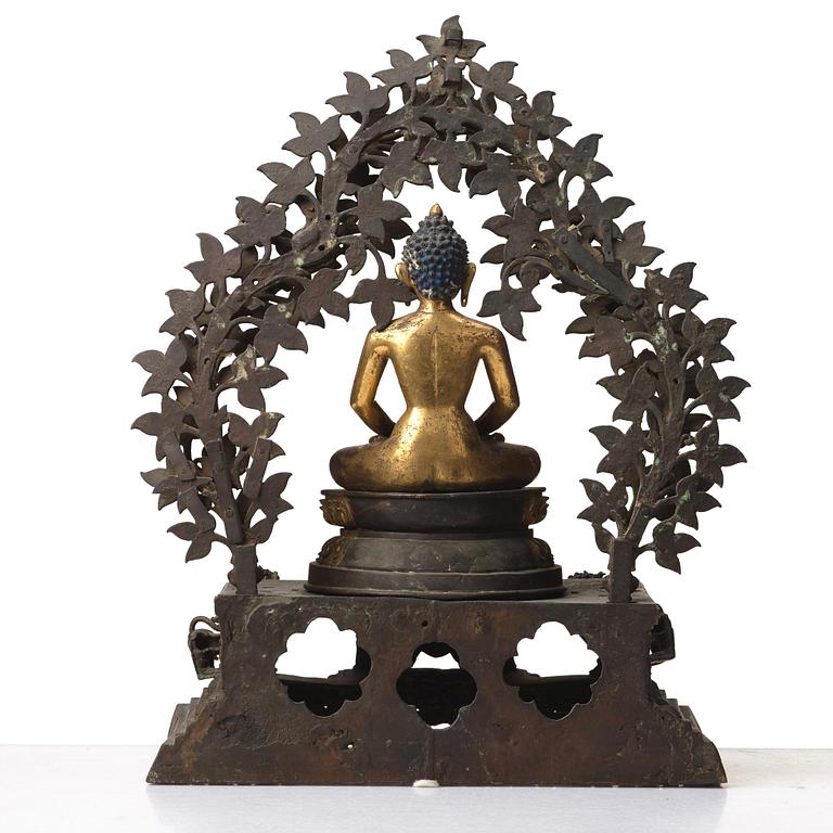A large Nepalese gilt bronze buddha on a throne with mandorla, 18/19th Century.