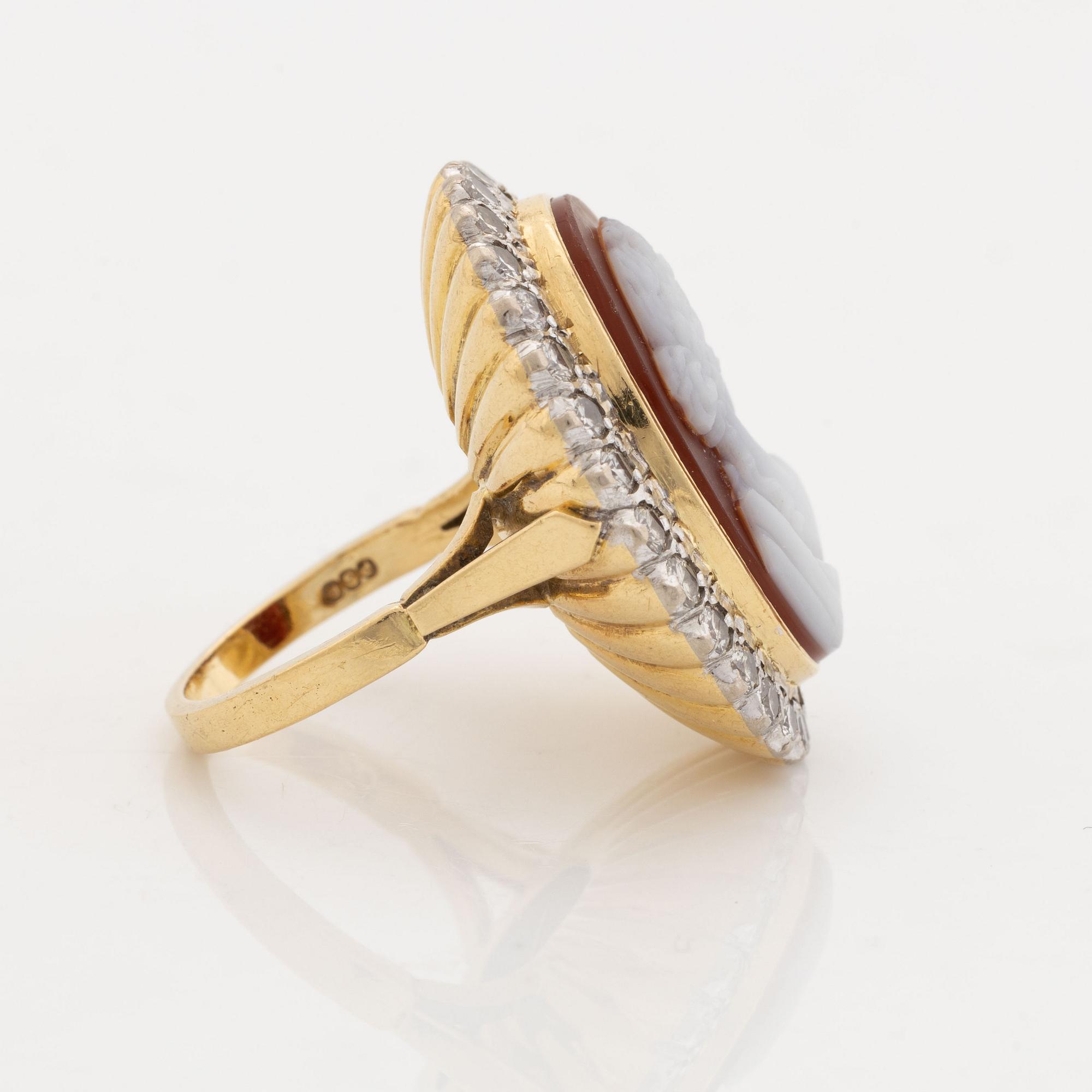 An 18K gold ring set with a hardstone cameo.