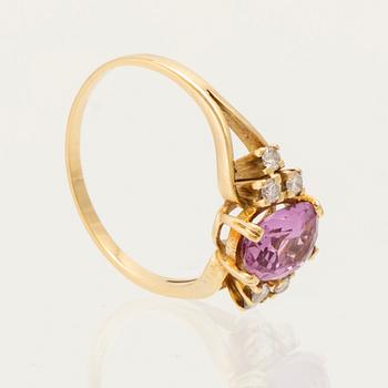 An 18K gold ring set with an oval faceted pink gemstone and round brilliant-cut diamonds.