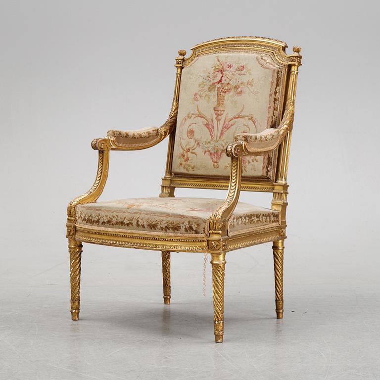 A gilt Louis XVI style armchair from around the year 1900.