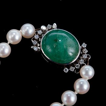 A NECKLACE, cultivated pearls Ø 6 mm, clasp with a cabochon cut emerald c. 13.5 ct, 16 x 14 mm.