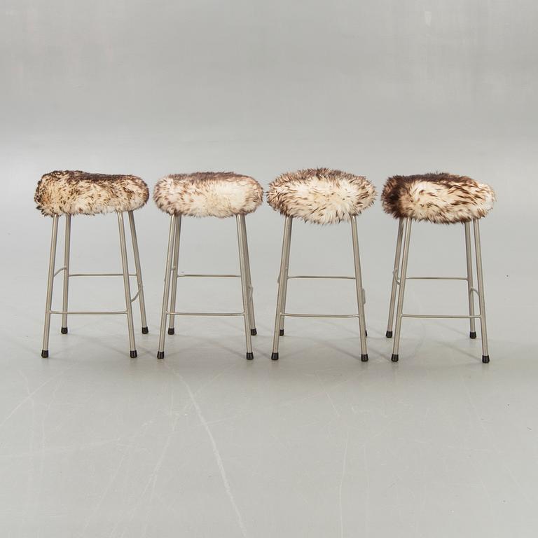 A set of four modern stolls with sheepskin.