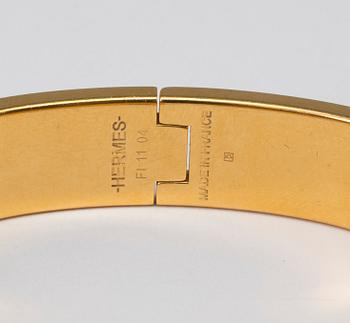 Black enamel and golden bracelet "Clic H" by Hermès.