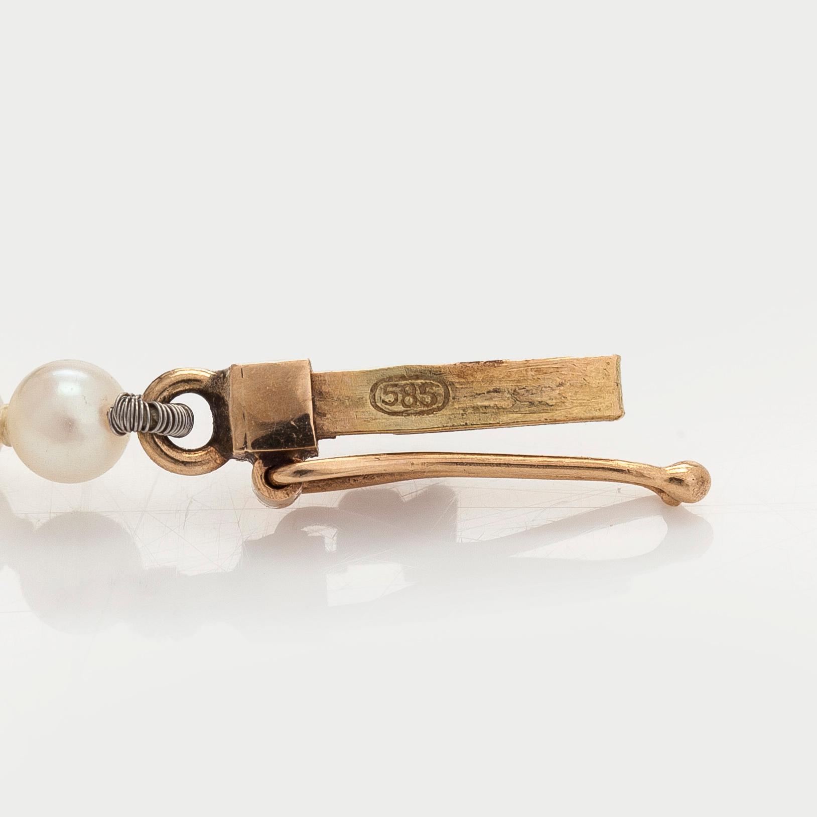A graduated cultured pearl necklace, clasp in 14K gold.