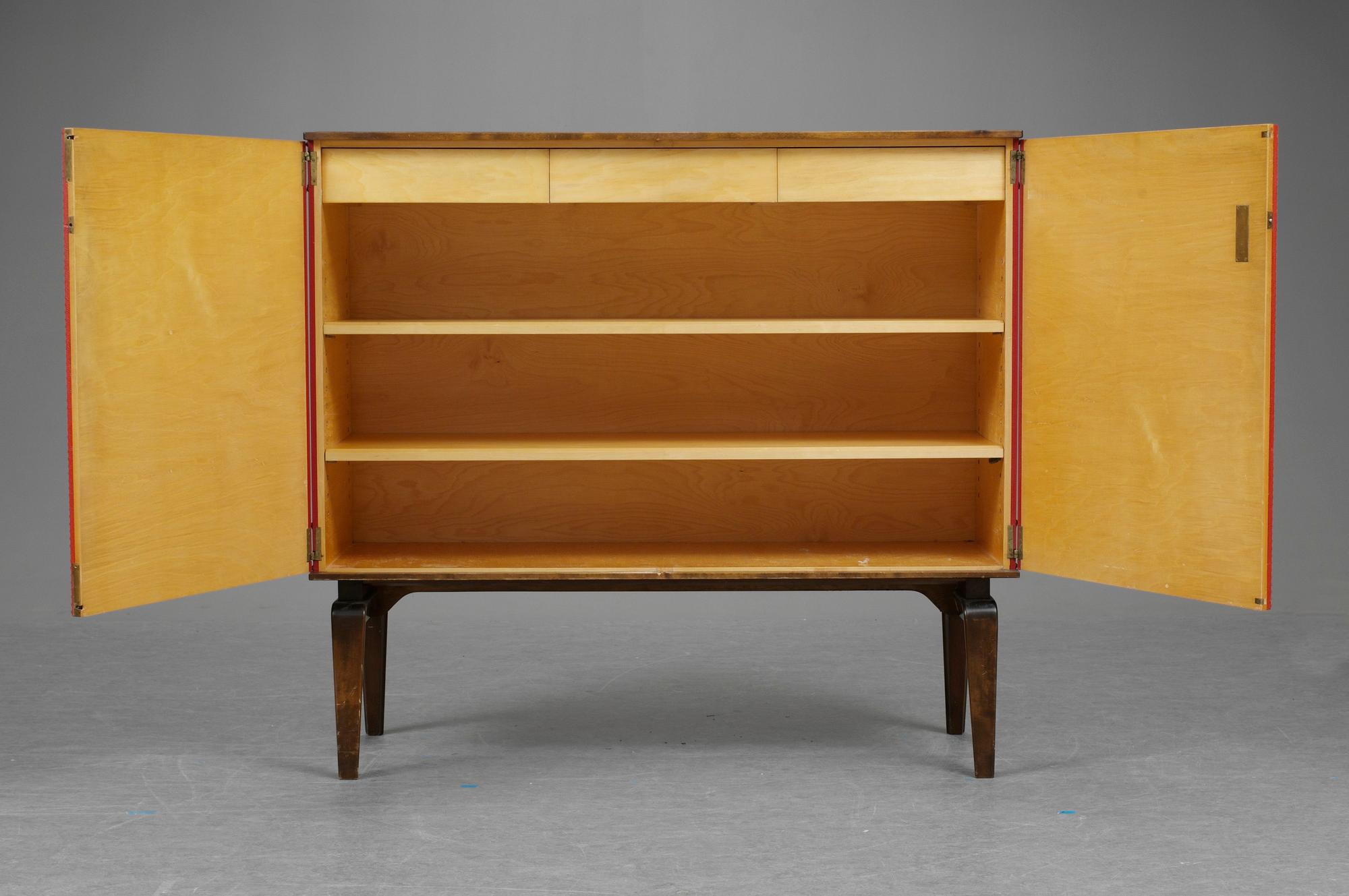 An Otto Schulz cabinet on stand with artificial red leather and brass details on a stained oak and birch stand, by Boet, Gothenburg, probably 1950's.
