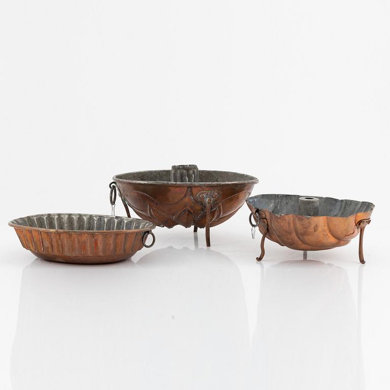 Four cake moulds, and a funnel, copper, 18th and 19th Century.