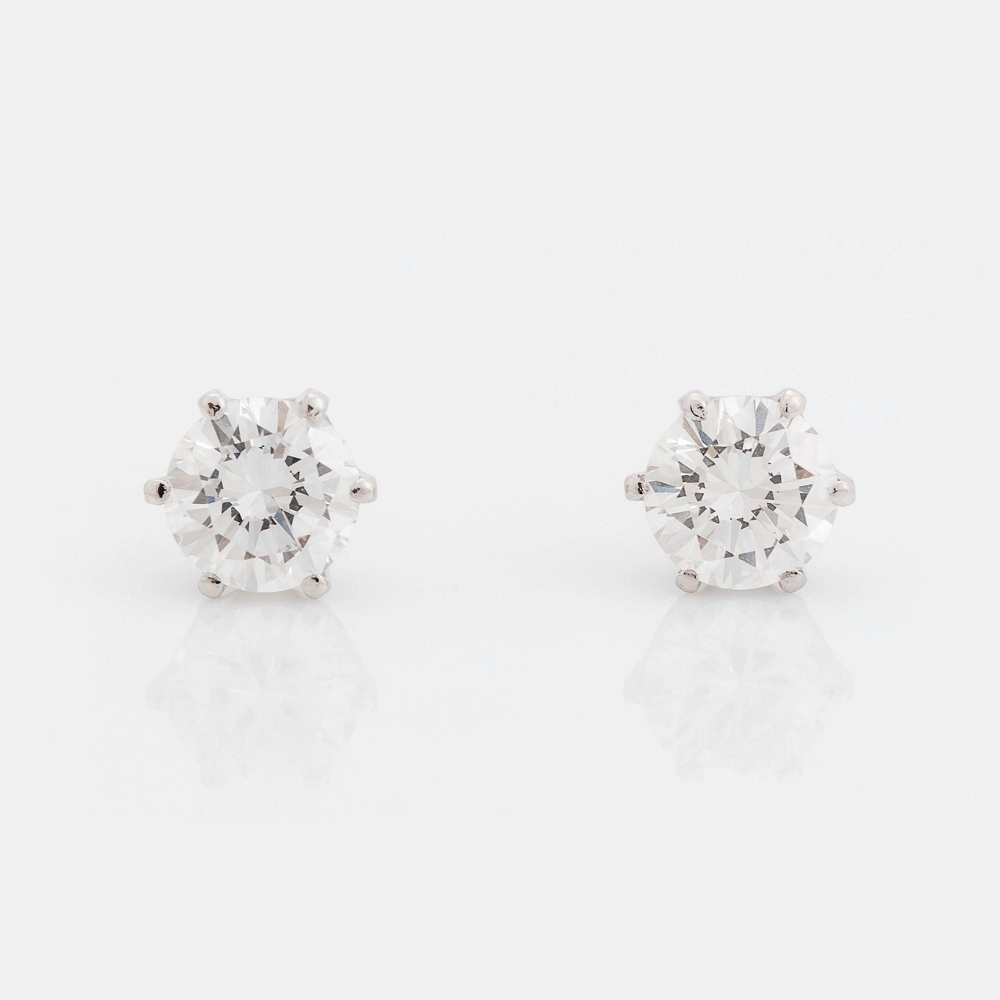 A pair of 18K white gold earrings set with two round brilliant-cut diamonds.