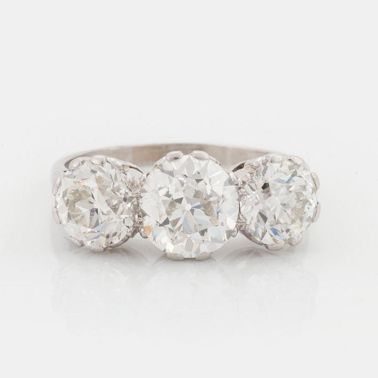 A platinum ring set with three old-cut diamonds.