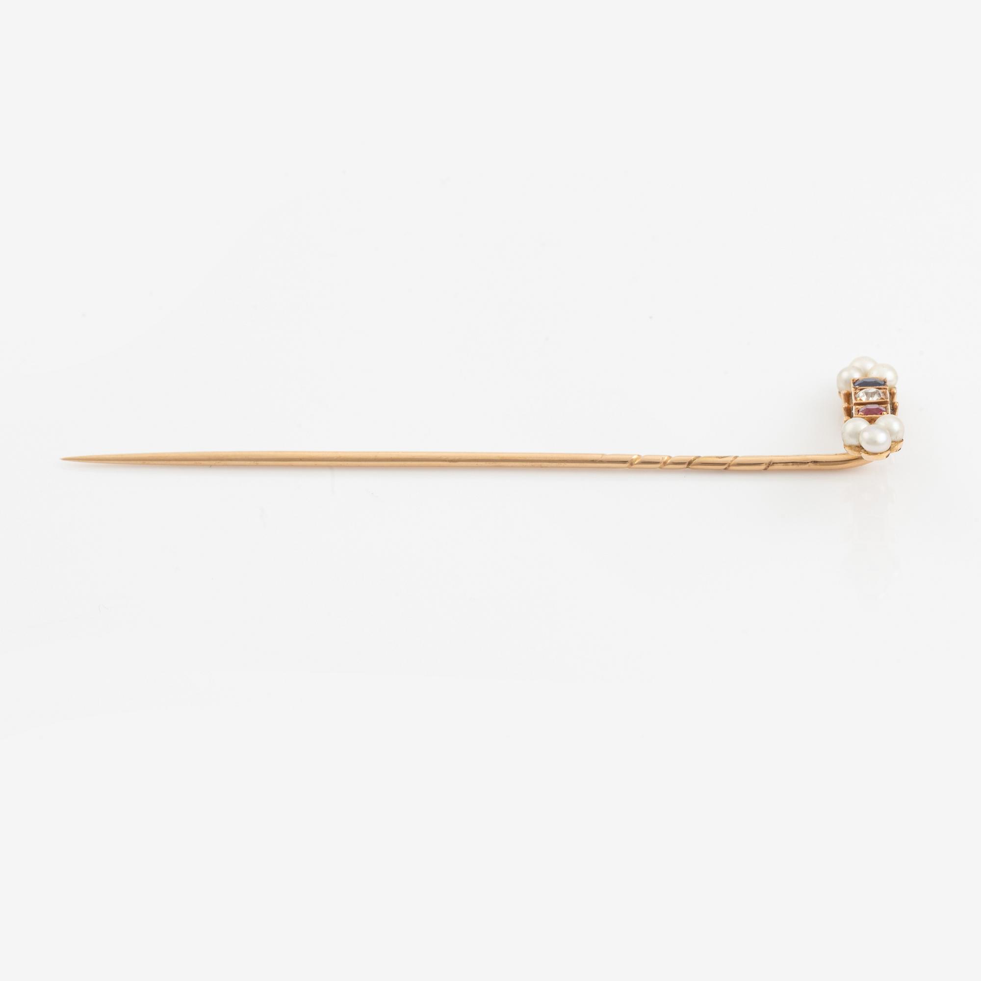 A 14K gold pin brooch with an old-cut diamond, pearls, and colored stones.