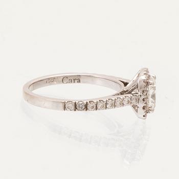 An 18K white gold ring set with a modified cushion-cut diamond and round brilliant-cut diamonds.