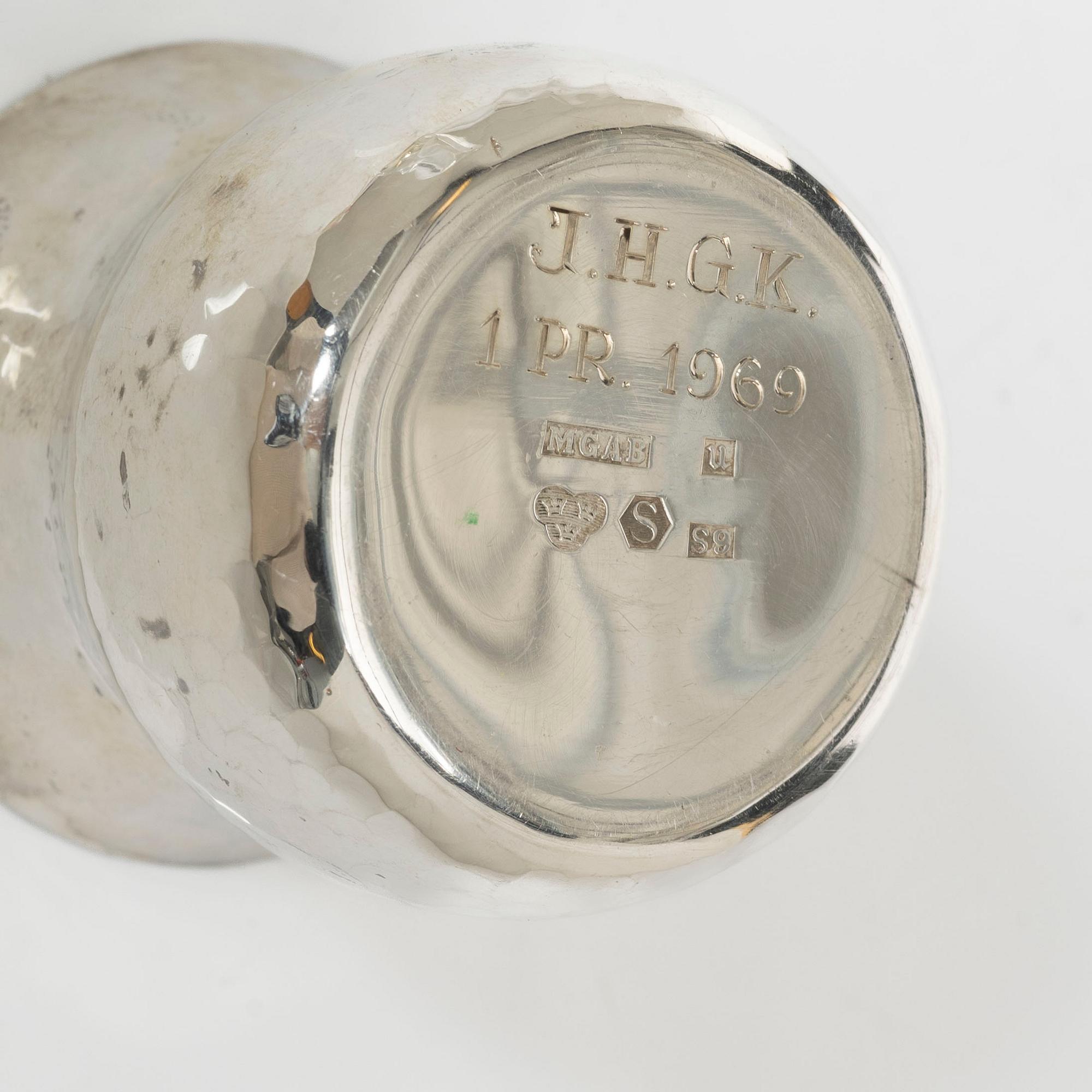 A pair of beakers, two napkin rings, and 17 pieces of cutlery, silver.