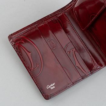Cartier, a burgundy patent leather handbag and wallet.