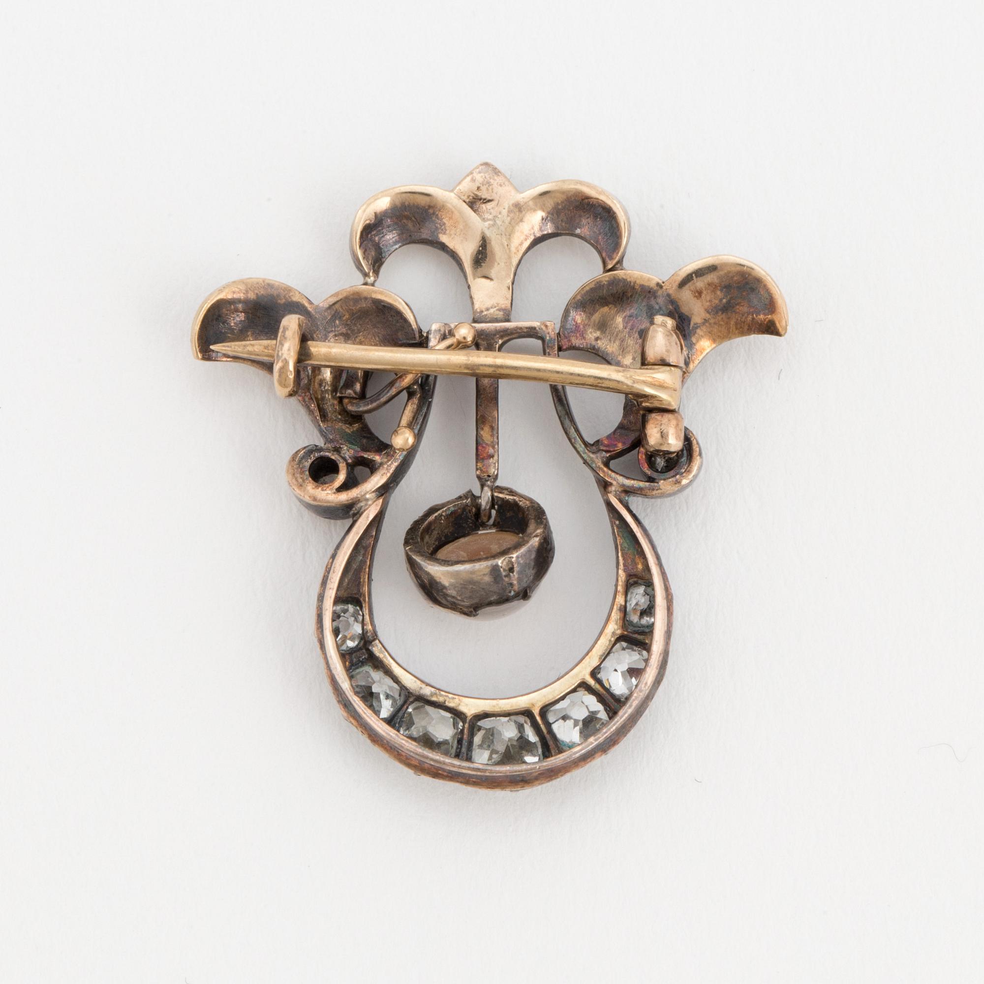 A brooch set with a mabé pearl and old-cut diamonds.