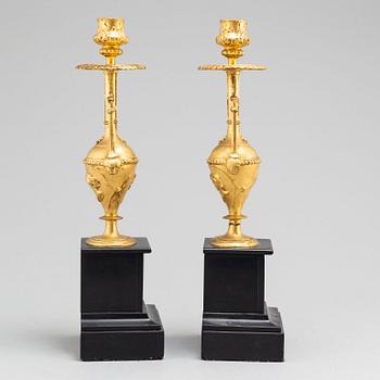 A late 19th century table clock and a pair of candlesticks.