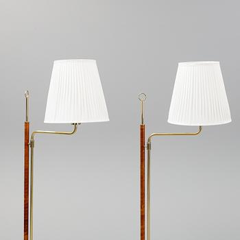 A pair of brass and leather floor lights.