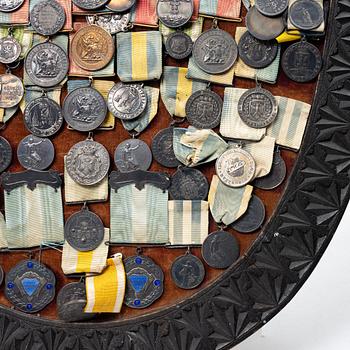 Idrottsmedaljer på märkessköld. Delvis silver. Sverige 1900-talets första hälft.
