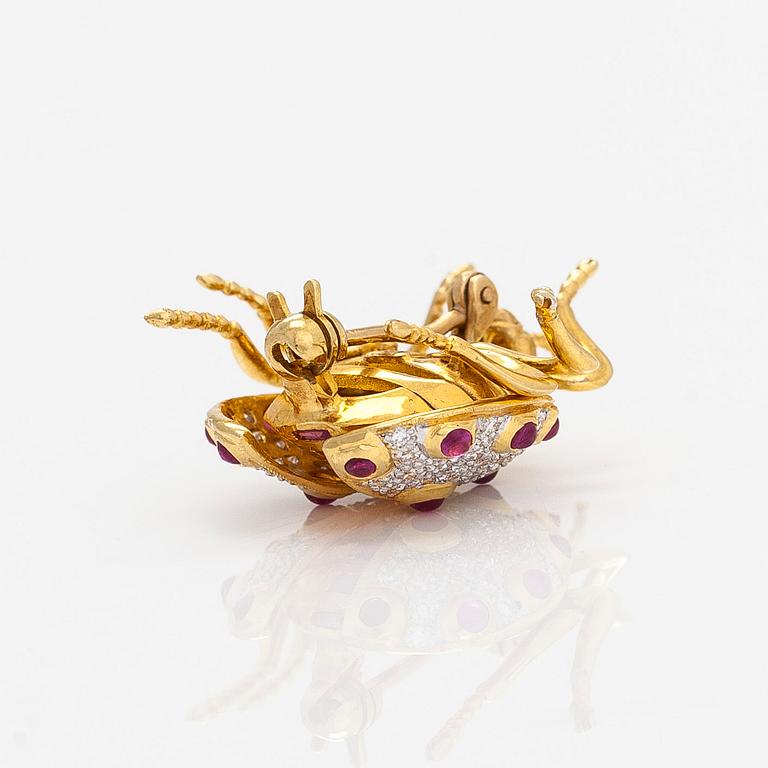 An 18K gold ladybug brooch, with rubies and diamonds.