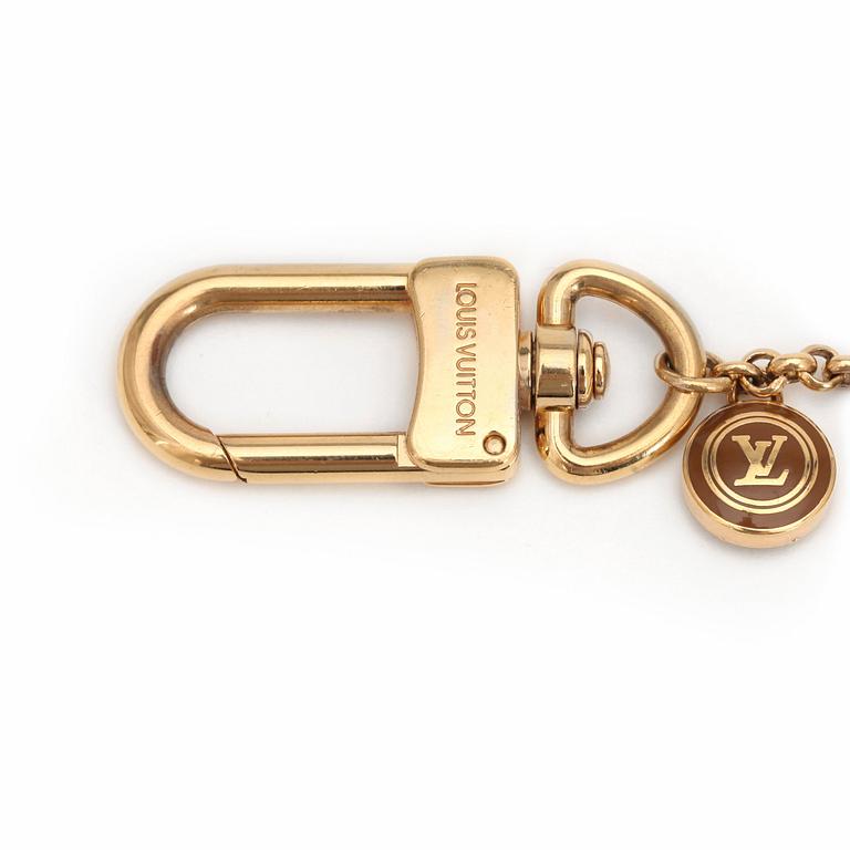 LOUIS VUITTON, a brass bag charm.