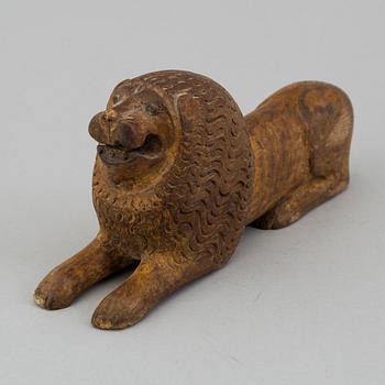 A carved wood sculpture of a lion from the 19th century.