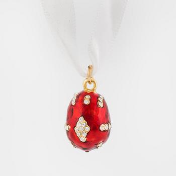 An egg-shaped pendant decorated with white paste stones to red enamel ground.