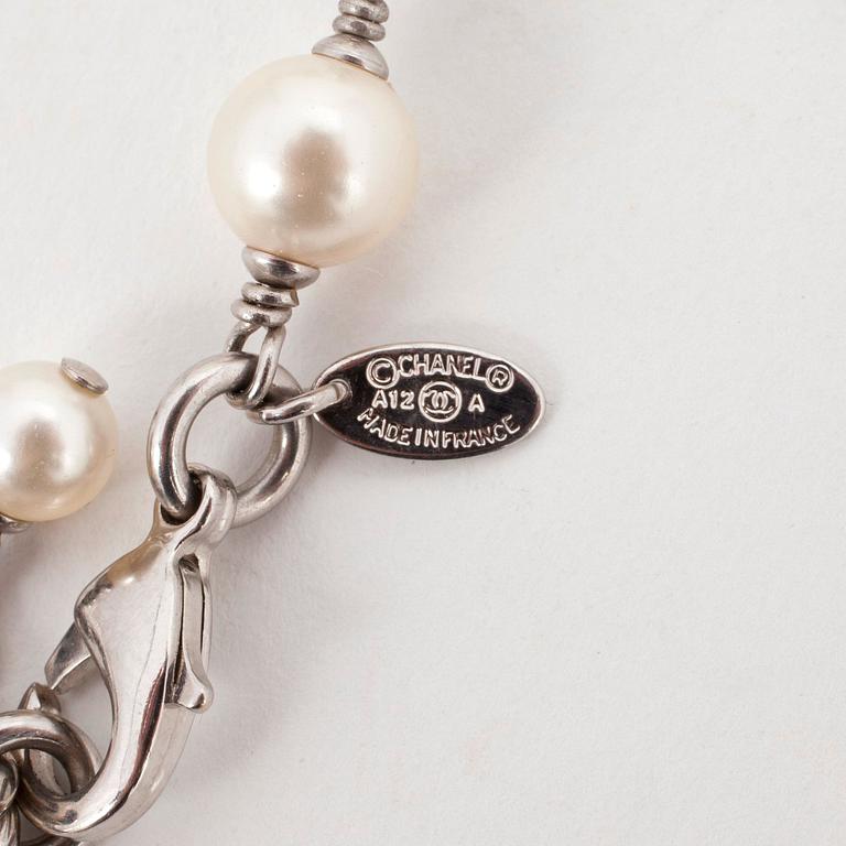 CHANEL, a decorative white pearl necklace.