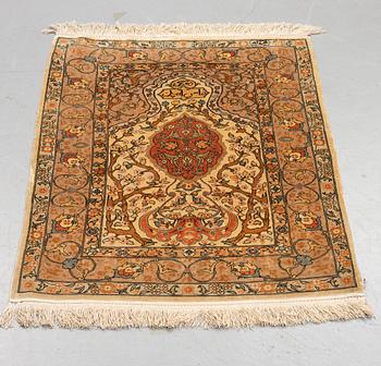 A rug, old silk Hereke, signed, ca 84,5 x 66 cm.