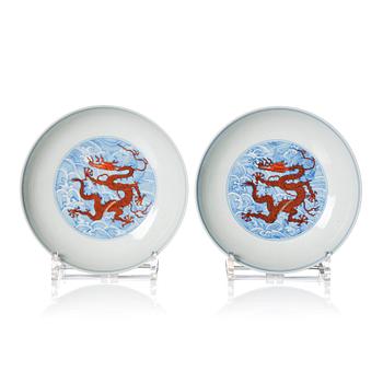 1010. A pair of blue and white and iron red decorated dragon dishes, Qing dynasty with Qianlong mark.