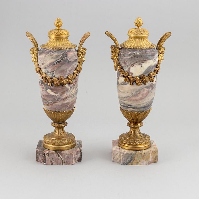 A pair of marble urns with bronze mountings from around year 1900.