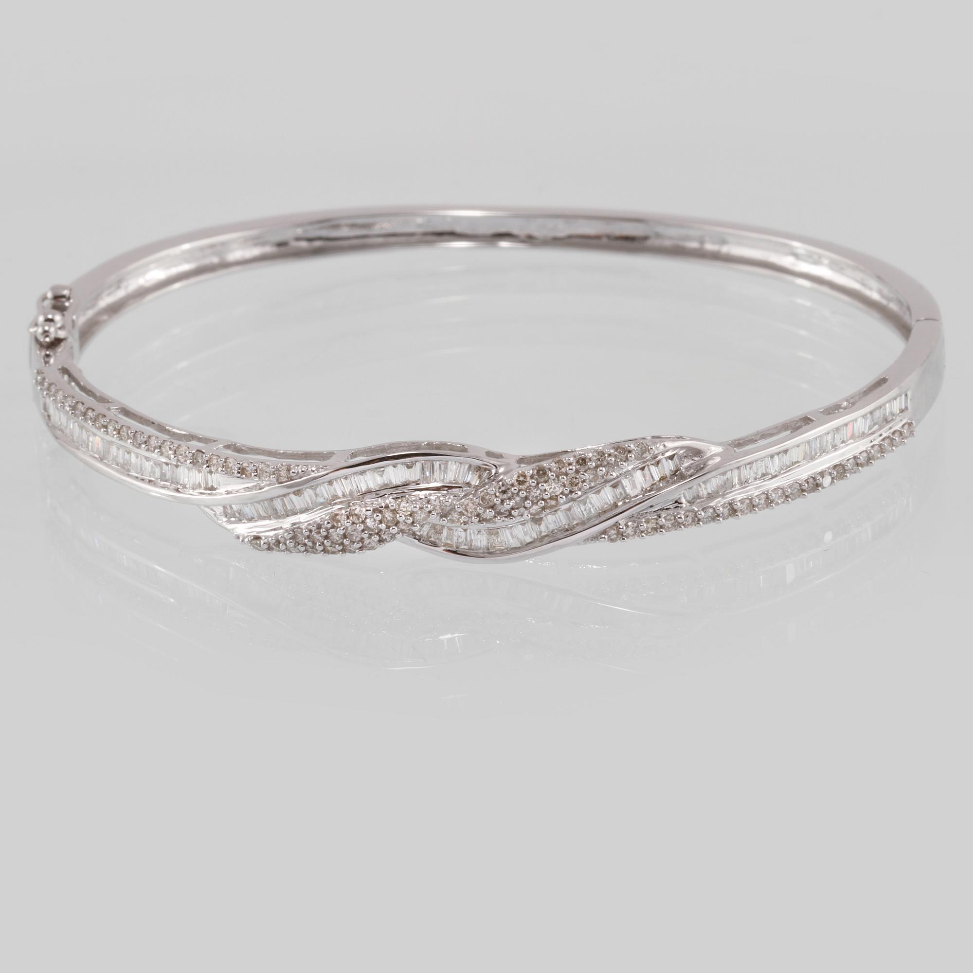 ARMRING, 18K vitguld med briljant och baguettslipade diamanter 1.08 ct. Vikt 12,3 gram.